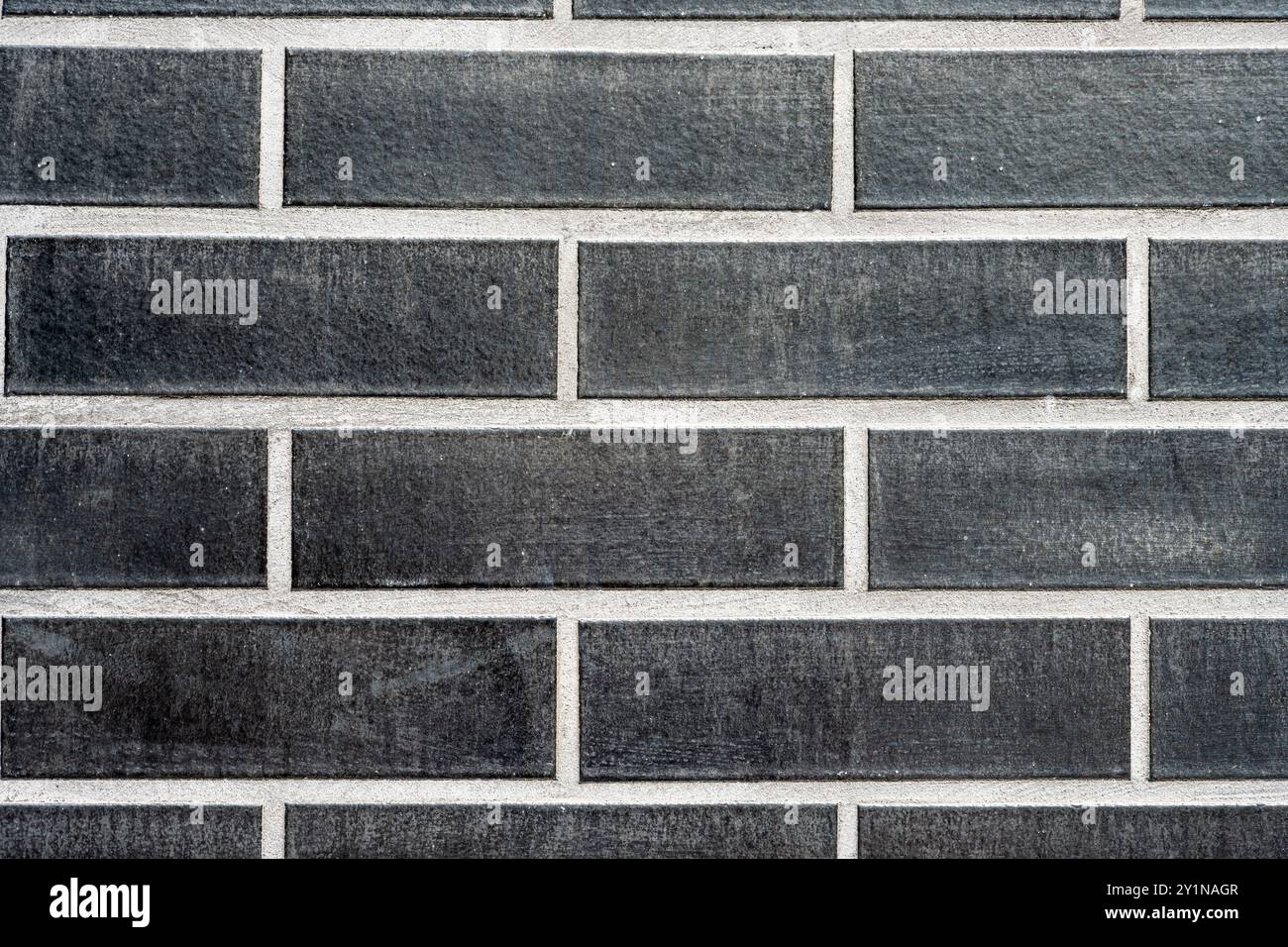 Background from a clinkered wall with black bricks Stock Photo