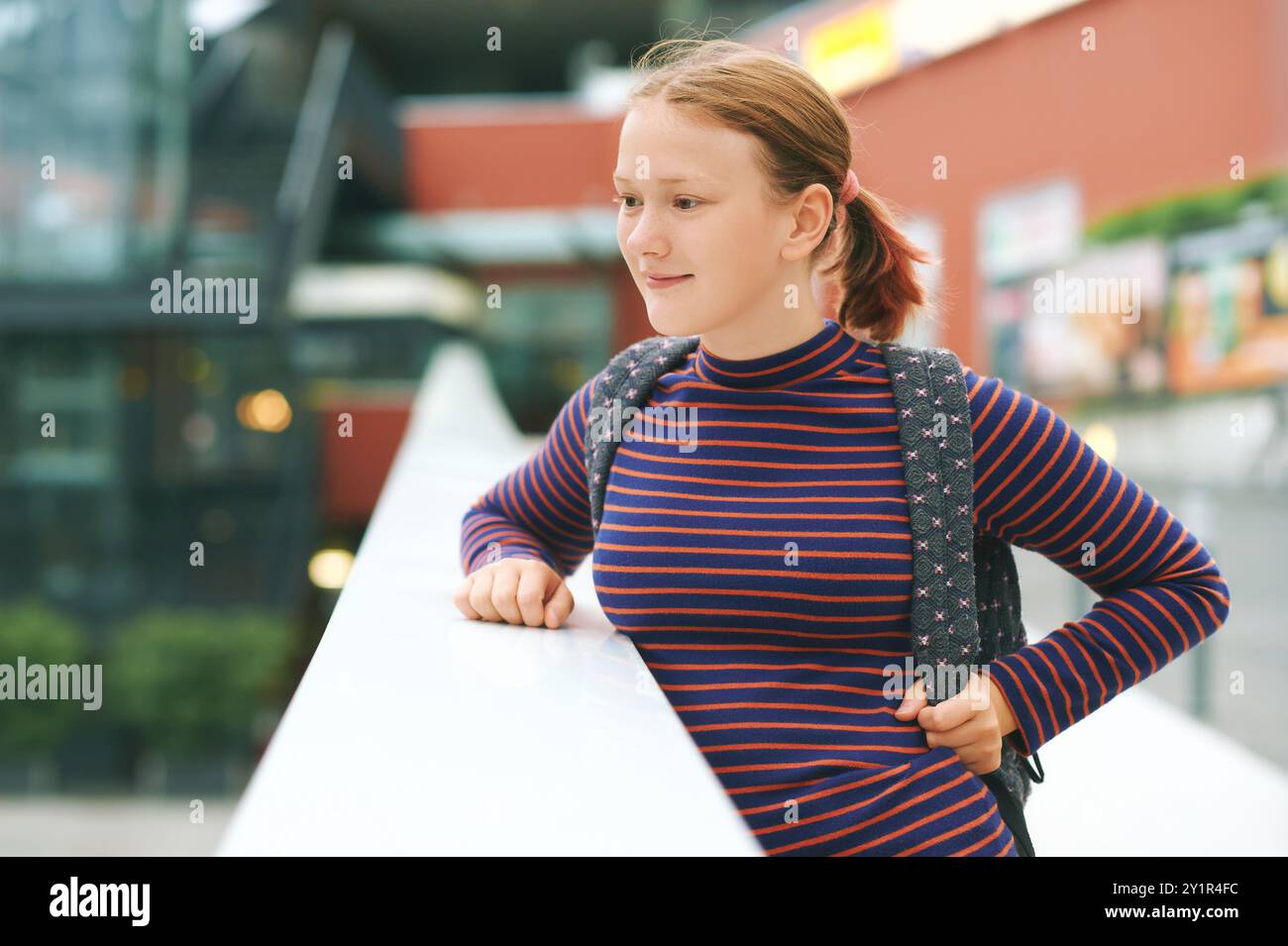 Portrait of young teen girl posing outdoors, wearing backpack Stock Photo