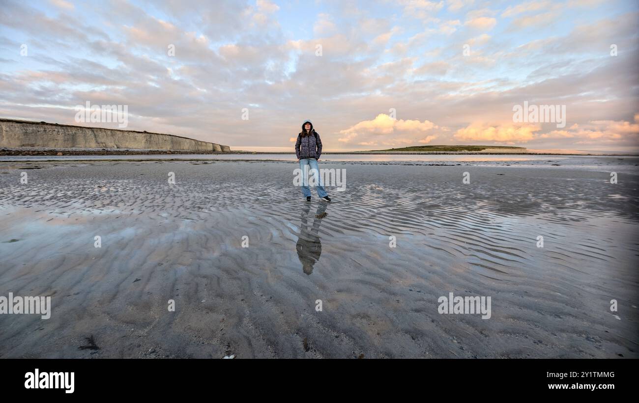 woman hiker backpacker enjoying coastal sunset scenery at sandy Silverstrand beach, Galway, Ireland, adventure and lifestyle concept, people in nature Stock Photo