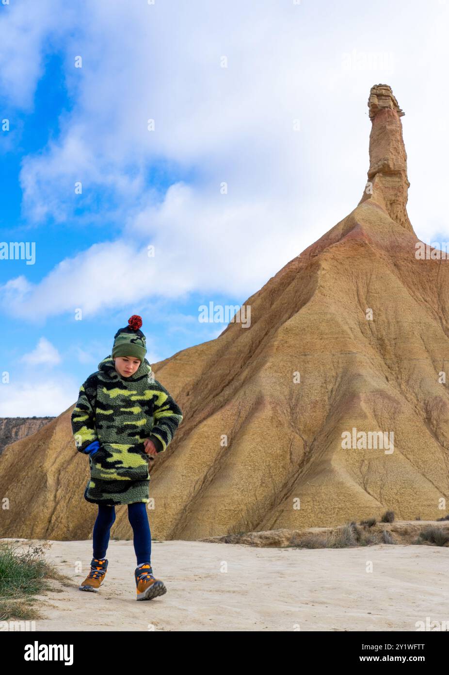 Boy walking through a desert landscape Stock Photo