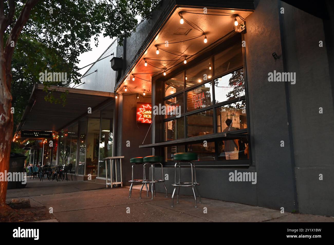 Pizza Box Raleigh Soft lights illuminate the sidewalk during twilight outside the Pizza ...