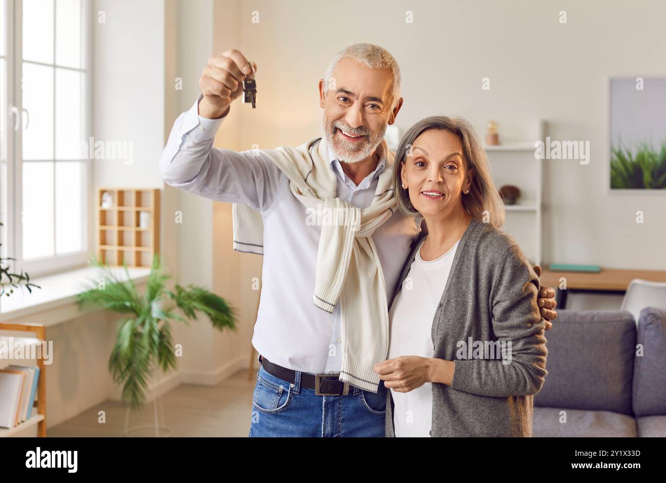 Elderly Couple Celebrating New Home Purchase, Showing Keys And Happy ...