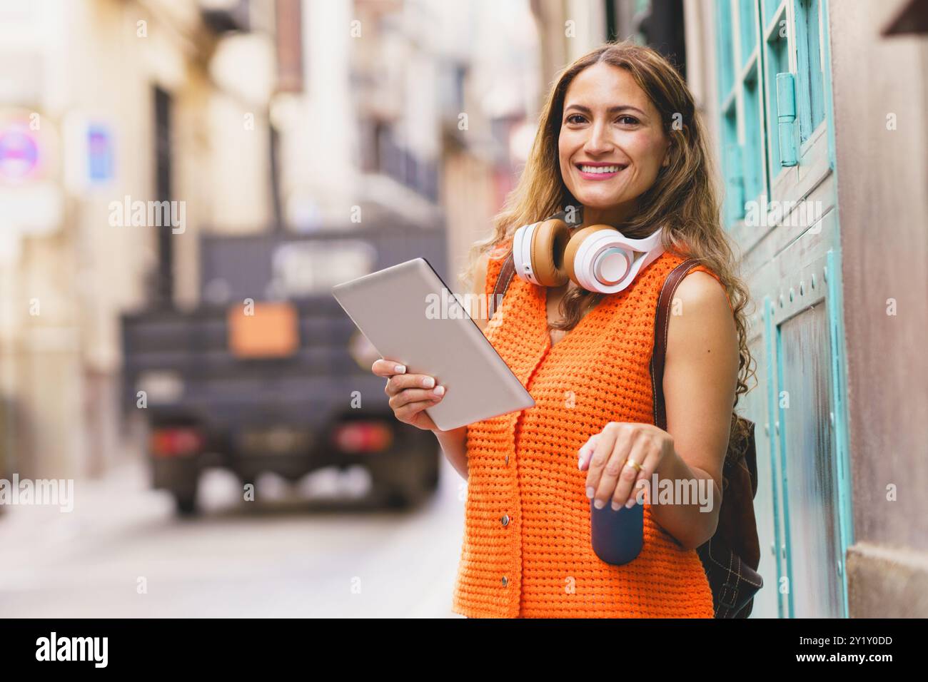 Student holding reusable water bottle while using digital tablet Stock Photo