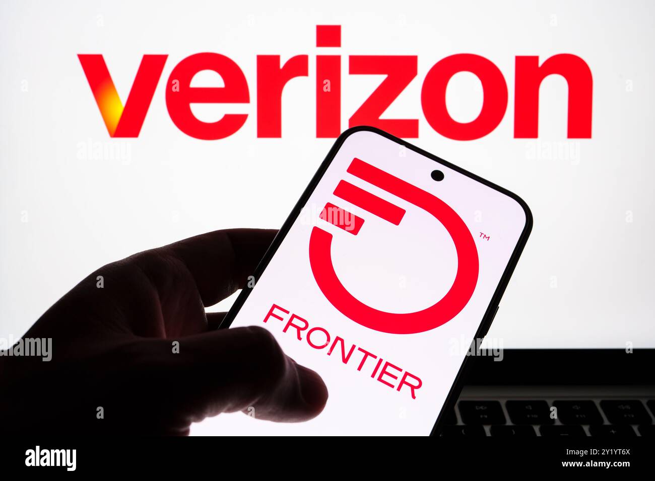 Verizon and Frontier Communications logos displayed on screen devices, emphasizing telecommunications partnership. Stafford, United Kingdom, September Stock Photo