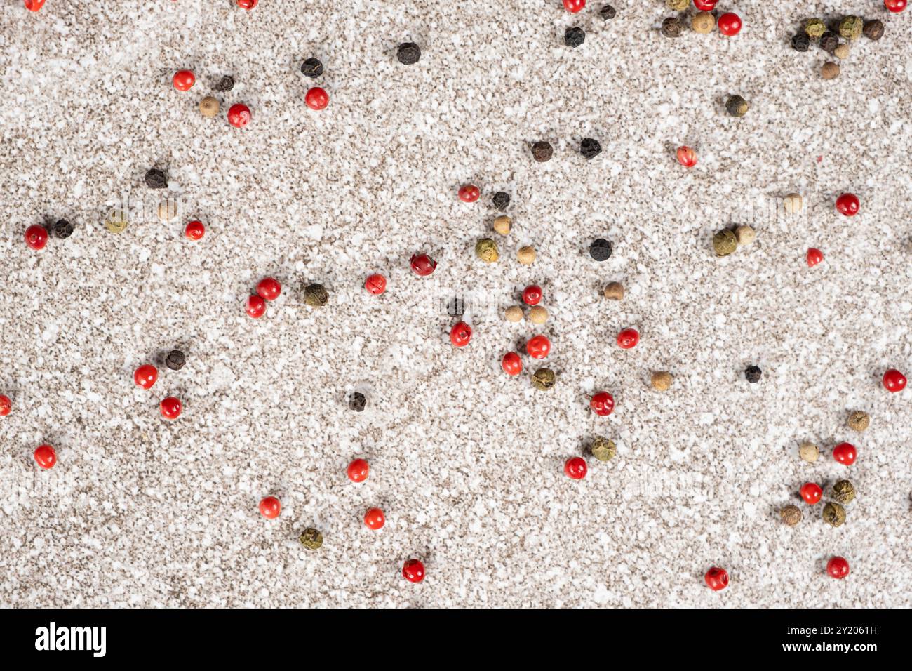 Multicolored peppercorns on a stone gray background. Stock Photo