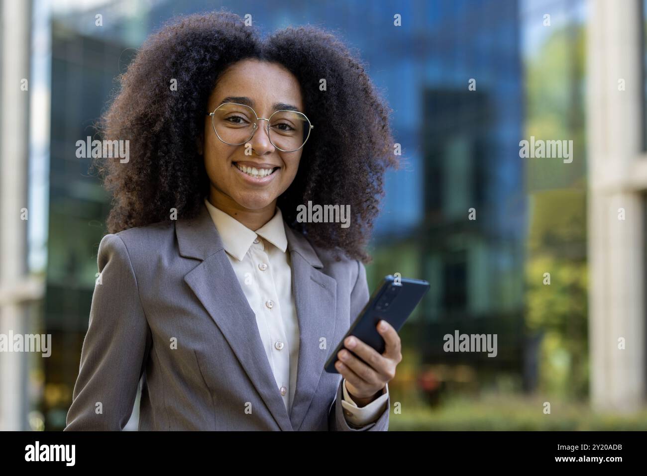 Smiling African American business woman in professional attire holding ...