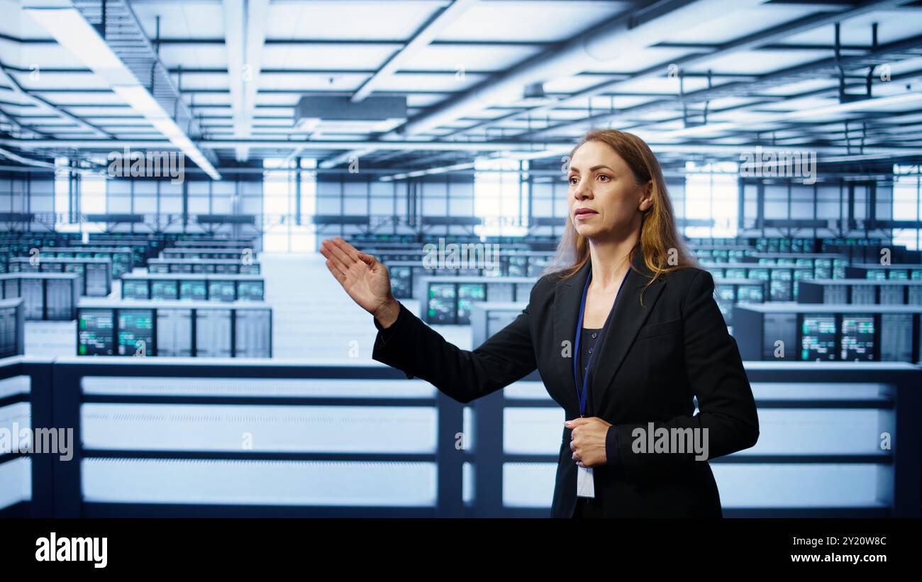System administrator in high tech data center looking at hologram visualization. Computer scientist working on securing server terminals using AR tech, preventing hacker attacks, camera B Stock Photo