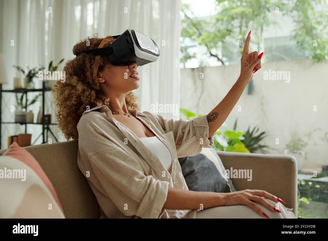 Woman Using VR Glasses At Home Stock Photo