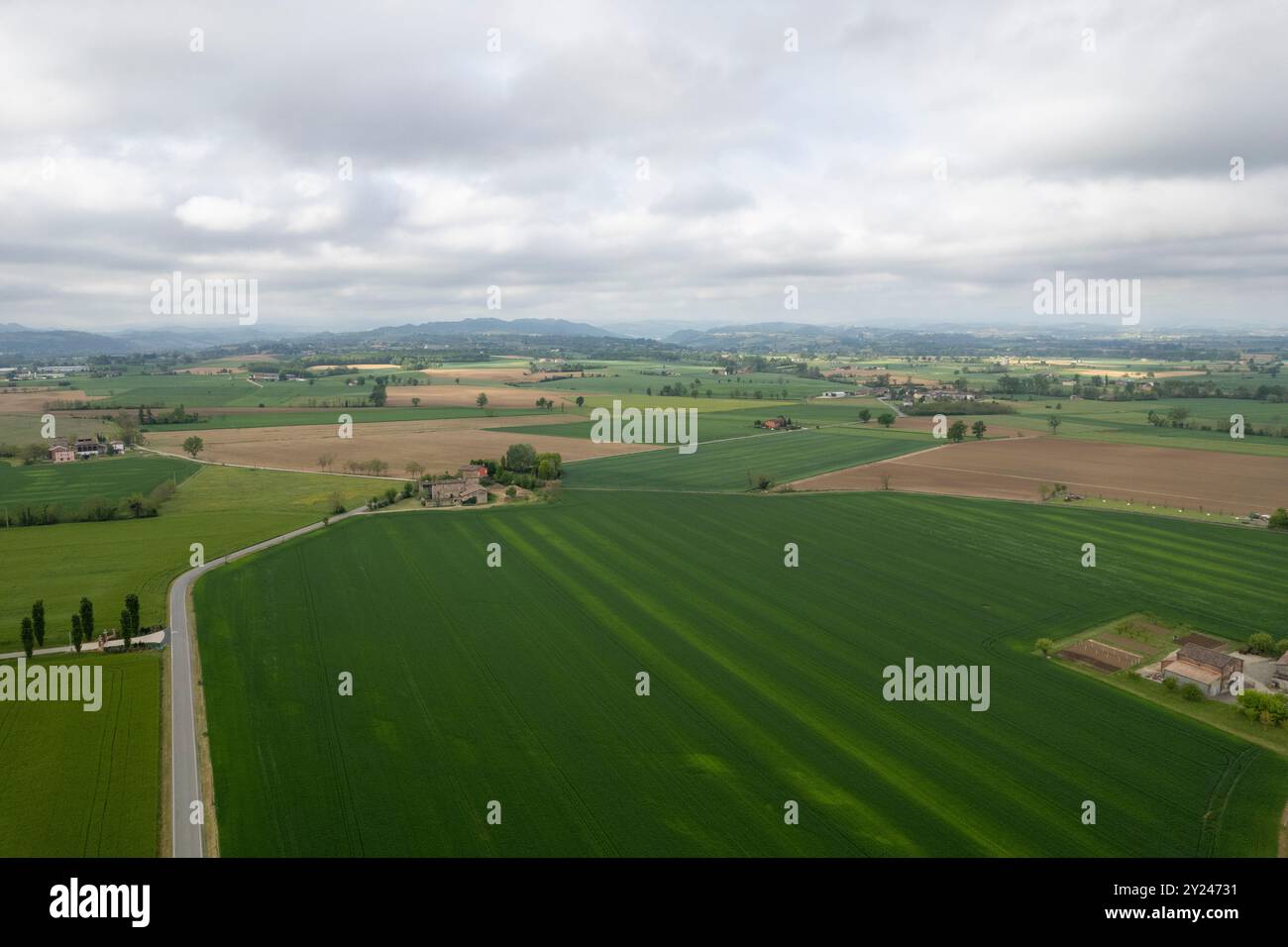 Aerial view of lush green countryside with winding road, farmhouses ...