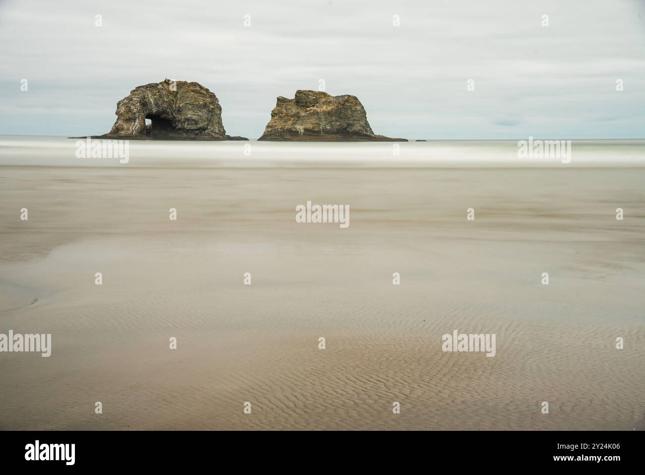 Quiet beach view of Arch Cape's sea stacks in a foggy Oregon setting. Stock Photo