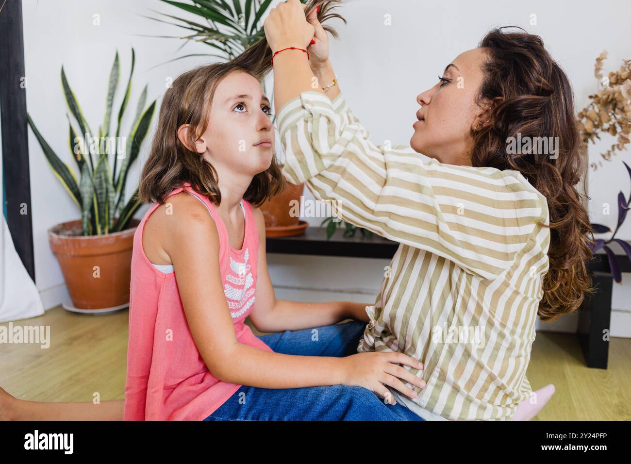 Head lices : mother examining nits to kid at home Stock Photo