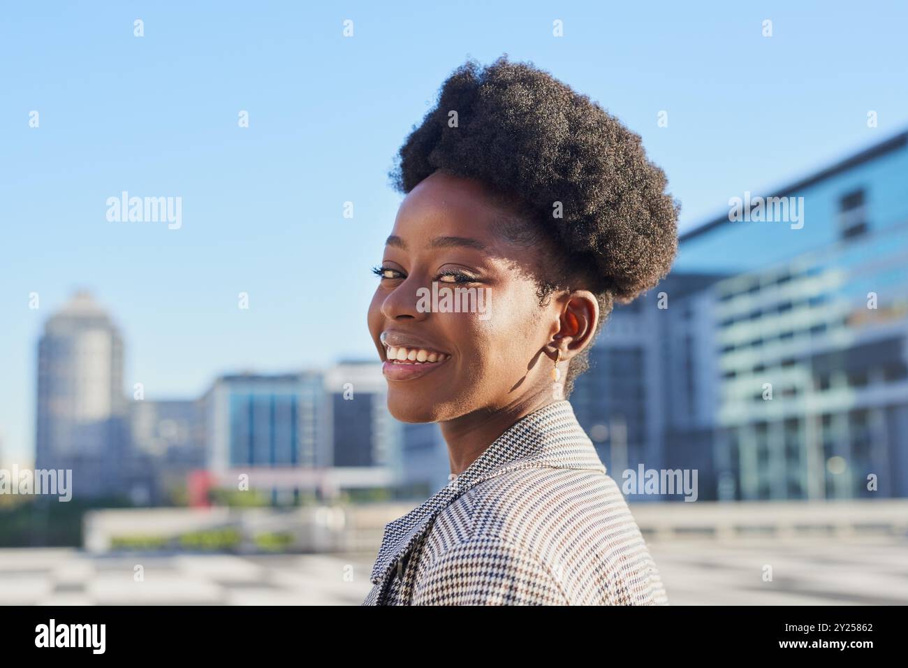 Confident Young Woman Smiling in Urban Cityscape Background Stock Photo