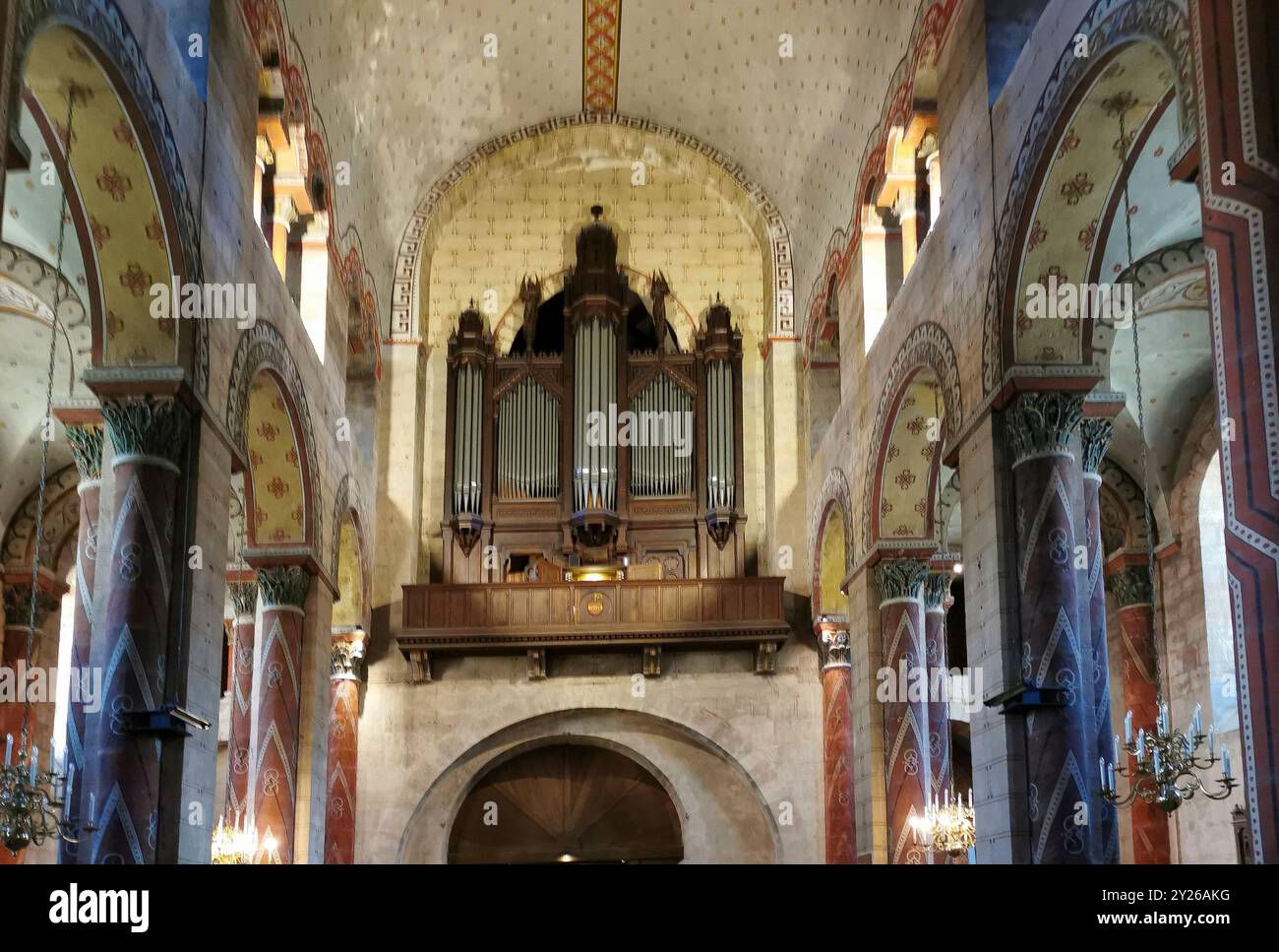 Interior showcasing a stunning organ and textured walls in natural light,  roman church Saint-Austremoine , Issoire, Auvergne-Rhone-Alpes, France Stock Photo