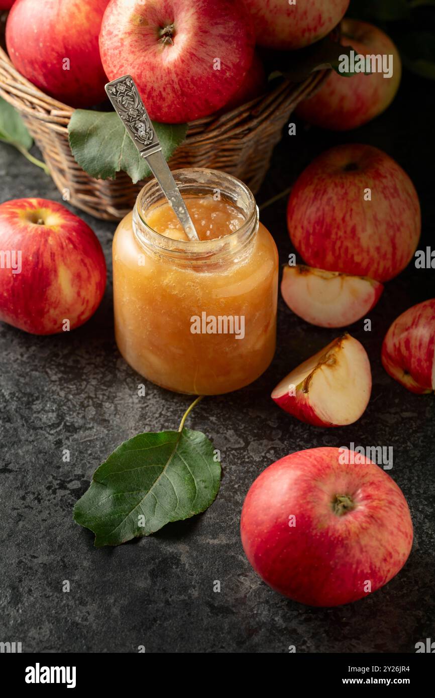 Apple jam and red fresh apples on a black stone table. Stock Photo