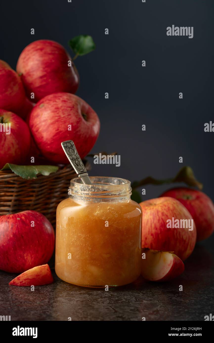 Apple jam and red fresh apples on a black stone table. Stock Photo