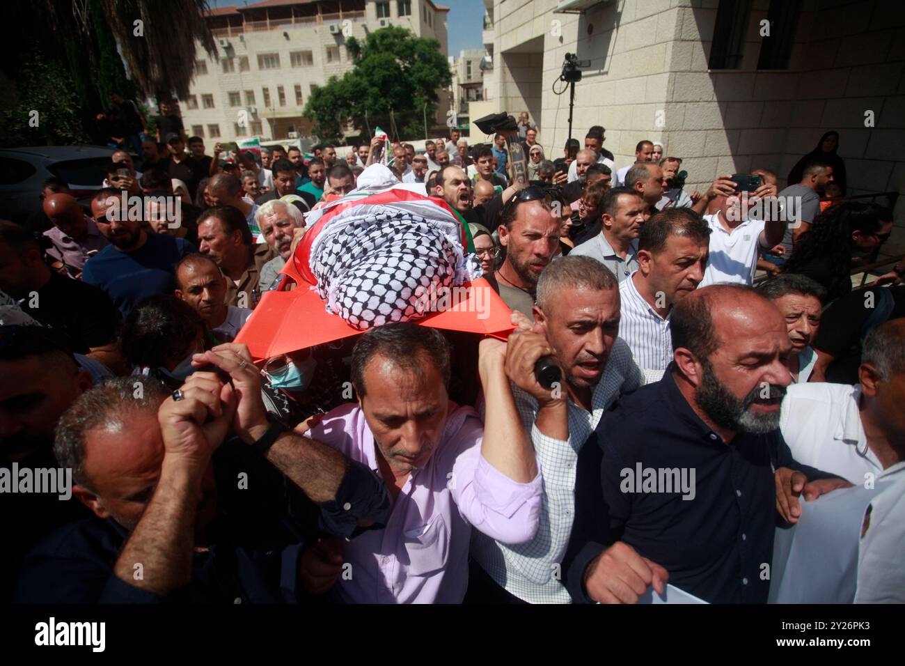 The body of Turkish-American activist Aysenur Ezgi Eygi, who was killed by Israeli forces on Friday, carried on shoulders, The body of Turkish-American activist Aysenur Ezgi Eygi, who was killed by Israeli forces on Friday, carried on shoulders, wrapped in the Palestinian flag, with the head covered by the traditional Palestinian keffiyeh during funeral procession in the West Bank city of Nablus on September 09, 2024. Eygi s body was taken from Rafidiyeh Hospital in Nablus with international solidarity activists, Palestinians, Turkiye s Consul General in Jerusalem, Ambassador Ismail Cobanoglu, Stock Photo