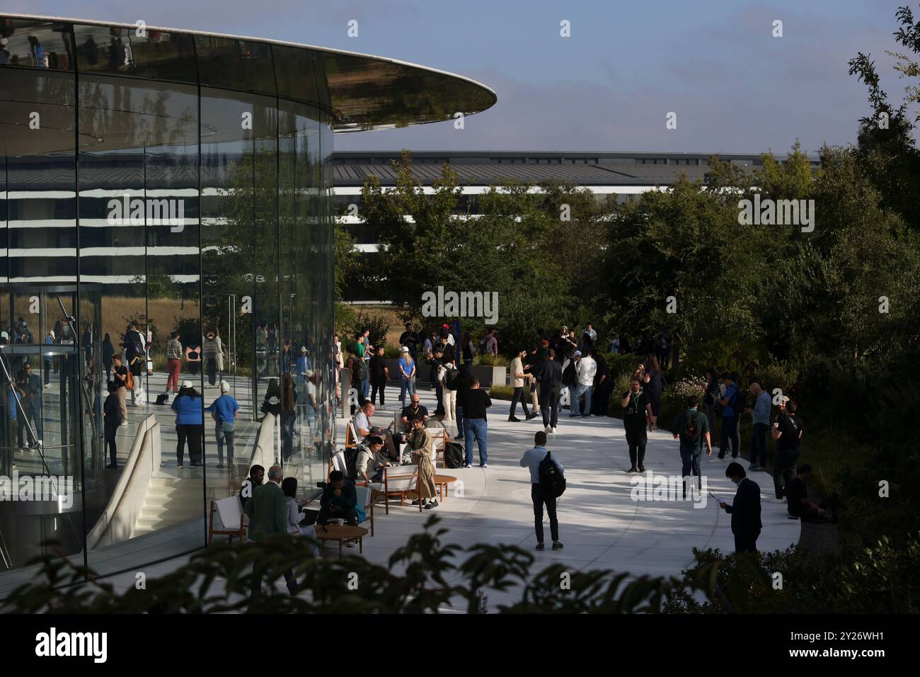 Attendees wait inside and outside the Steve Jobs Theater before an ...