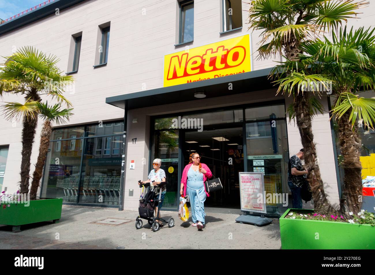 Netto Supermarket Shoppers Outside on Street Bayreuth Germany Bavaria Old Woman with Cart Senior Elderly Females, Palm Trees in pots Stock Photo