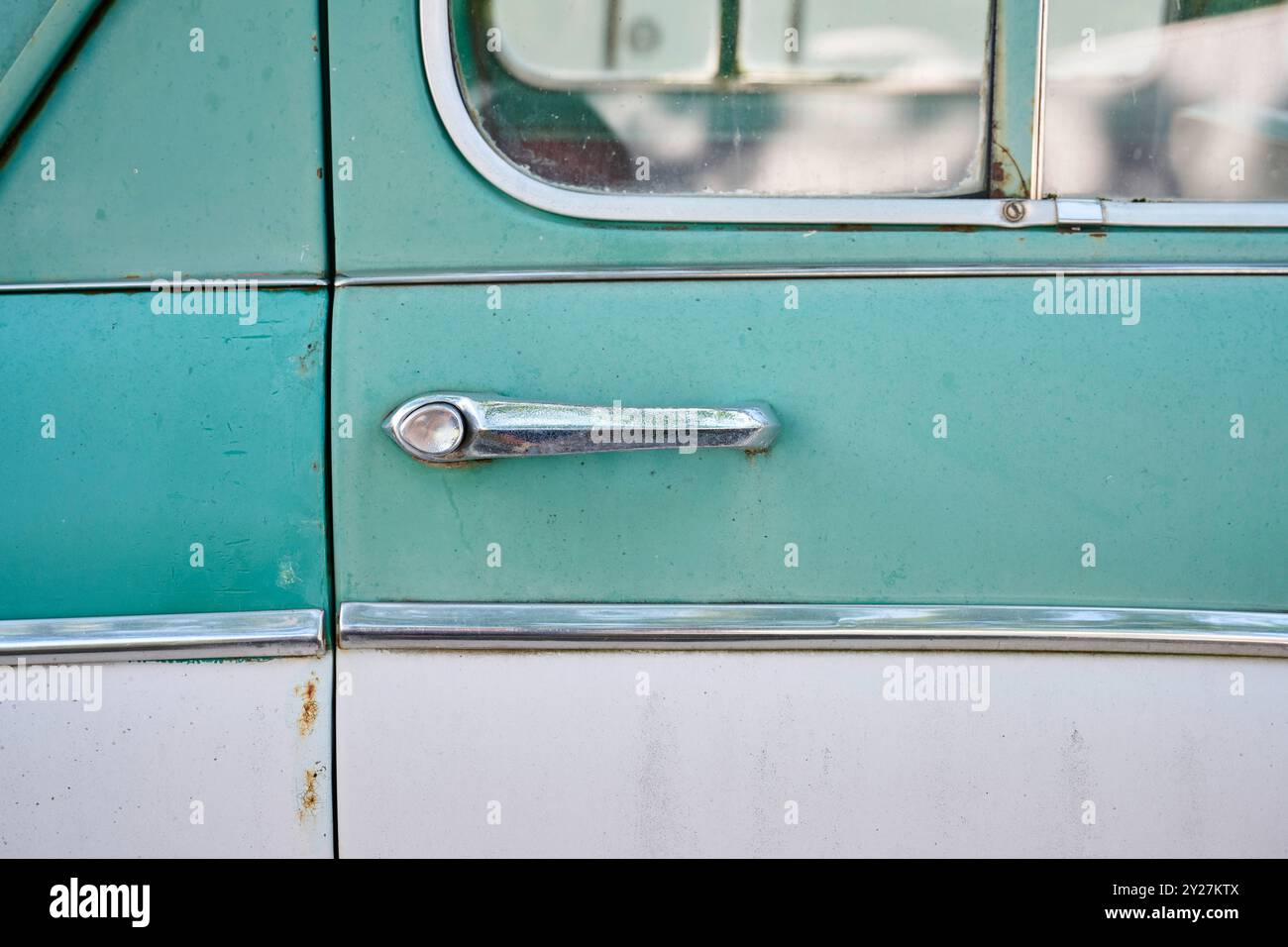 Detailaufnahmen eines alten Autos der Marke Moskwitsch uas den 50er- oder 60er-Jahren. Das Fahrzeug ist mingrün/beige und hat viele Chromteile. Stock Photo