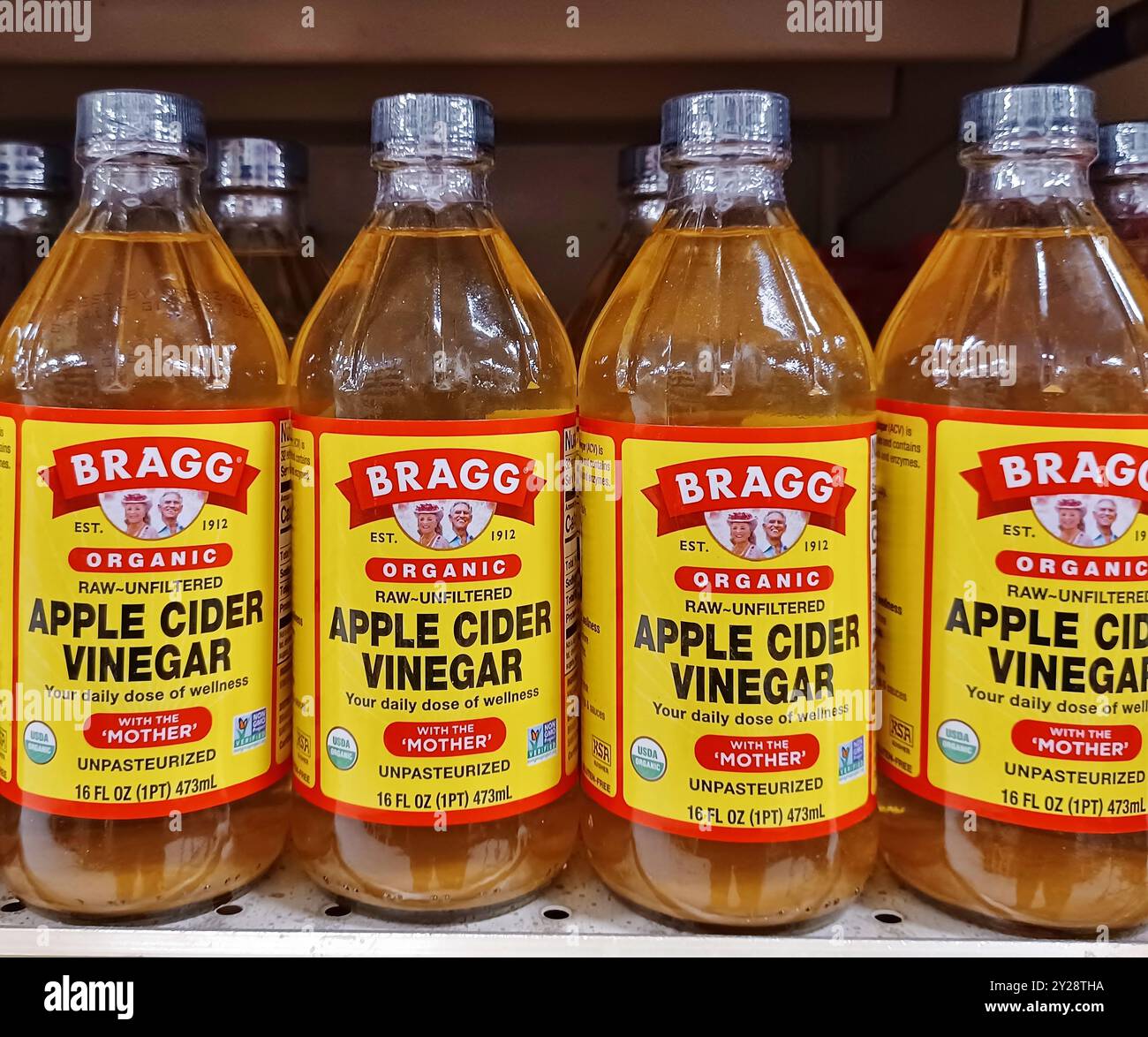 Houston, Texas USA 09-01-2024: Apple Cider Vinegar glass bottles Bragg brand name. Stock Photo