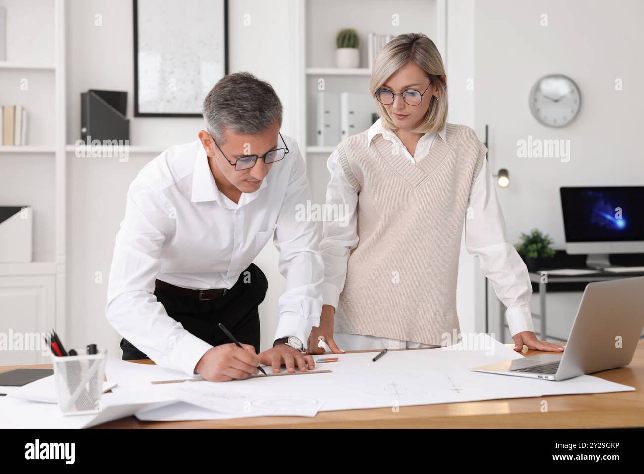 Architects making engineering drawing at wooden table in office Stock Photo