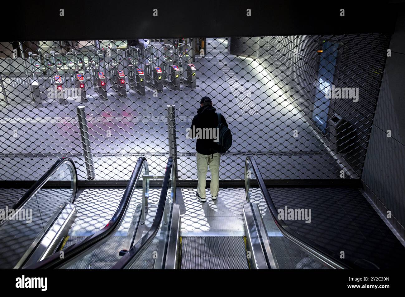 AMSTERDAM - A passenger stands in front of a closed subway station at Amsterdam Central Station during a work stoppage in Amsterdam's city transport system. From 4 a.m. to 8 a.m., streetcars, buses and subways were not running. Trade union FNV has announced several strikes in the week before Budget Day. The goal is to urge the cabinet to come up with a regulation that would allow ov employees to quit heavy work earlier. ANP RAMON VAN FLYMEN netherlands out - belgium out Stock Photo