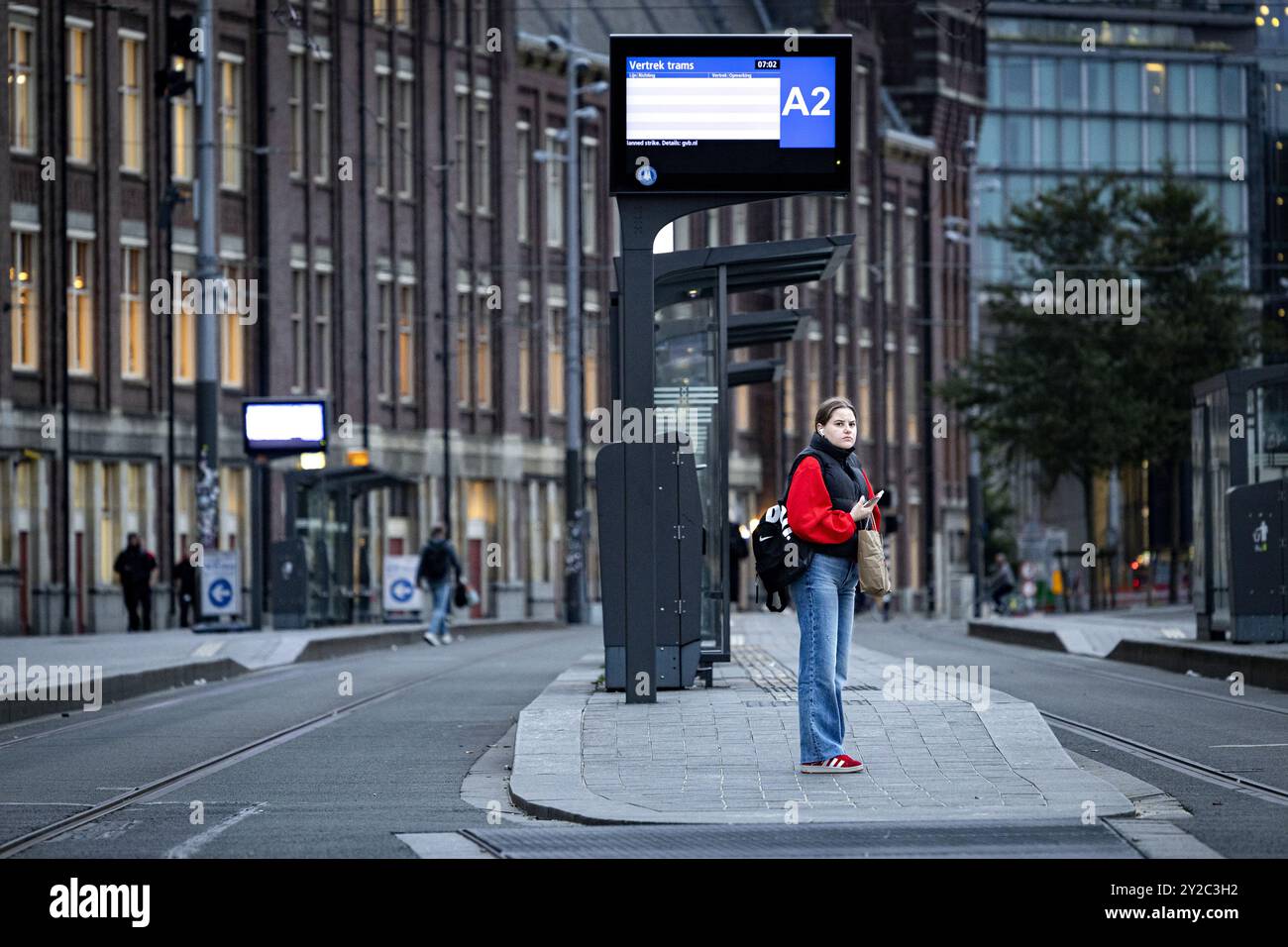 AMSTERDAM - A lost traveler at Amsterdam Centraal during a work stoppage in Amsterdam's city transport system. From 4 a.m. to 8 a.m. no streetcars, buses and subways were running. Trade union FNV has announced several strikes in the week before Budget Day. The goal is to urge the cabinet to come up with a regulation that would allow ov employees to quit heavy work earlier. ANP RAMON VAN FLYMEN netherlands out - belgium out Stock Photo