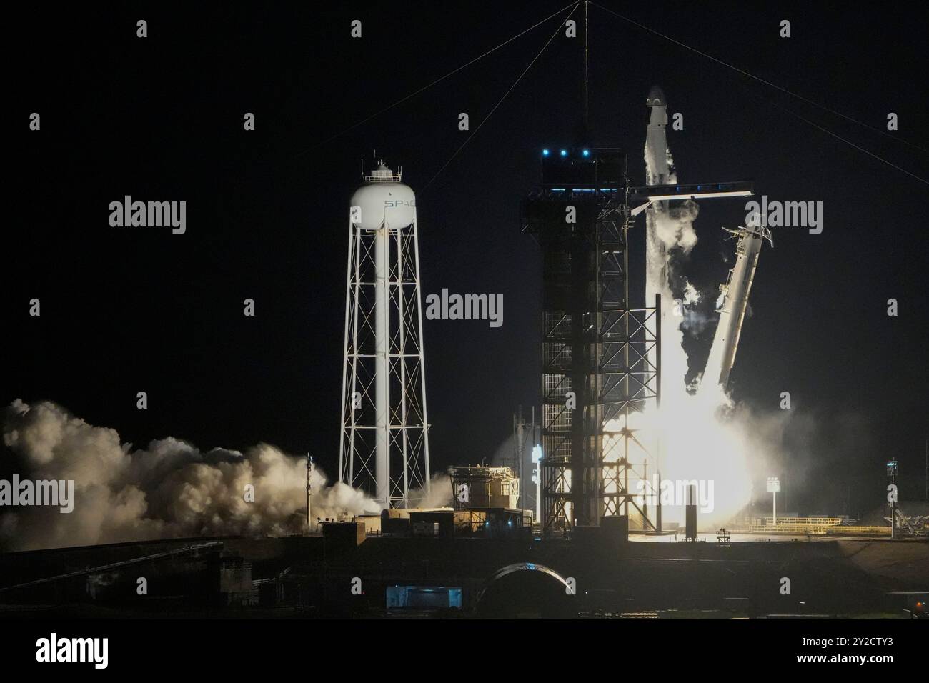A SpaceX Falcon 9 rocket with a crew of four lifts off from pad 39A at ...