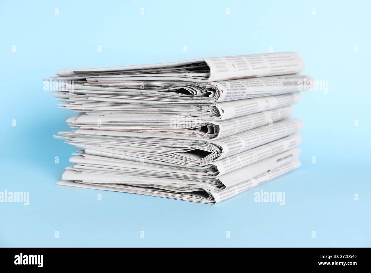 Stack of newspapers on light blue background Stock Photo