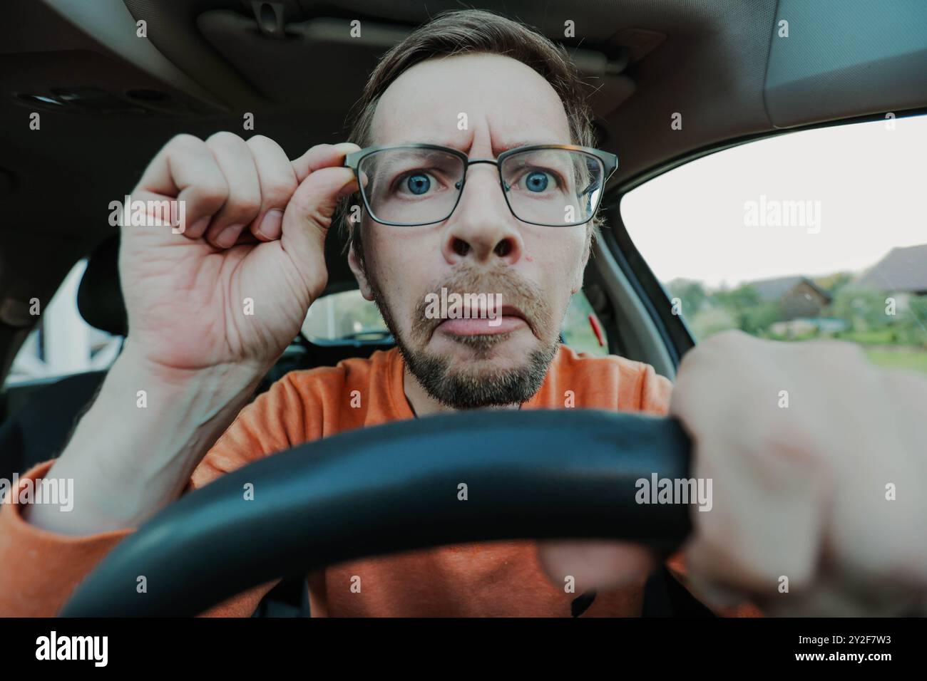 Young man have problems with driving due poor eyesight, hand holding eyeglasses Stock Photo