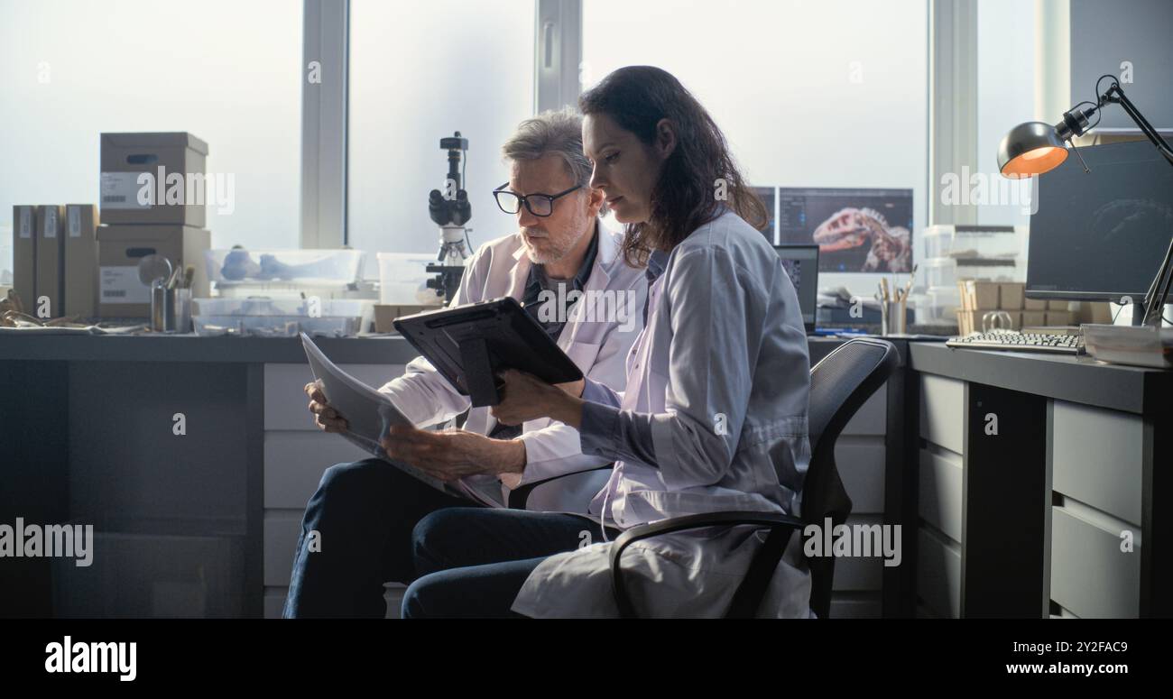 Male and female scientists in lab coats discuss scientific research ...