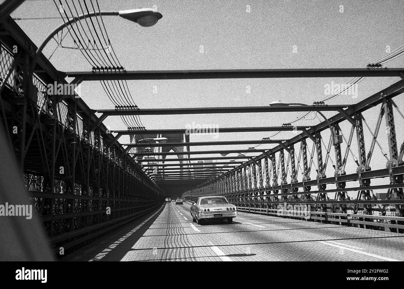 AJAXNETPHOTO. - JULY 1975. NEW YORK, USA. - ON THE VEHICLE DECK OF BROOKLYN BRIDGE SPANNING THE EAST RIVER FROM THE BROOKLYN SIDE TOWARDS LOWER MANHATTAN. PHOTO:JONATHAN EASTLAND/AJAX REF:750024 11A 92 Stock Photo