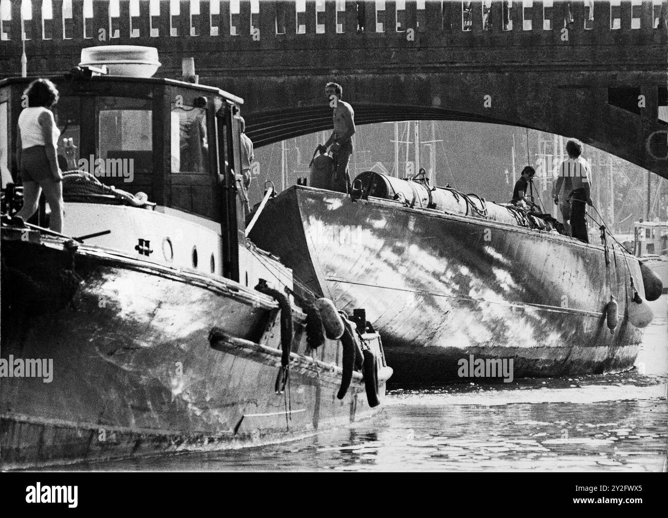 AJAXNETPHOTO. 24 AUGUST, 1978. BURSLEDON, ENGLAND. - NEW LIFE FOR AMERICA'S CUP YACHT - THE J CLASS YACHT ENDEAVOUR UNDER TOW BY THE TUG SLEDGEHAMMER PASSING UNDER THE A27 ROAD BRIDGE OVER THE HAMBLE RIVER TO HER NEW BERTH AT RIVERSIDE BOATYARD WHERE OWNERS JOHN AMOS AND GRAHAM JACK WILL BEGIN THE LONG PROCESS OF REBUILDING THE YACHT. PHOTO:JONATHAN EASTLAND/AJAXREF:2782408 2 Stock Photo