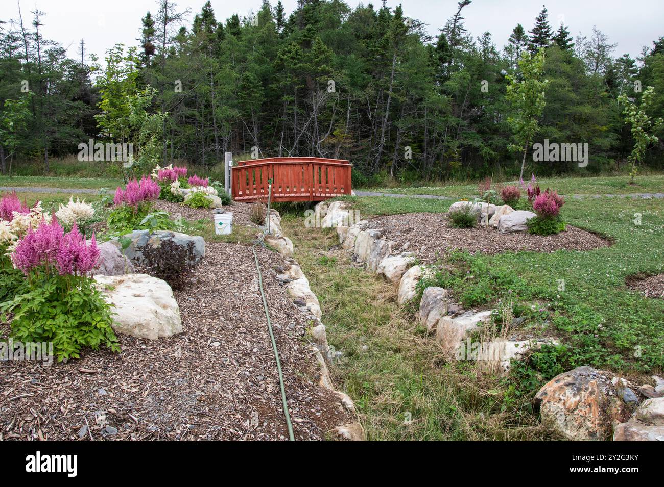 Bridge and summer flowers at the Cranford Family community park in New Harbour, Newfoundland & Labrador, Canada Stock Photo