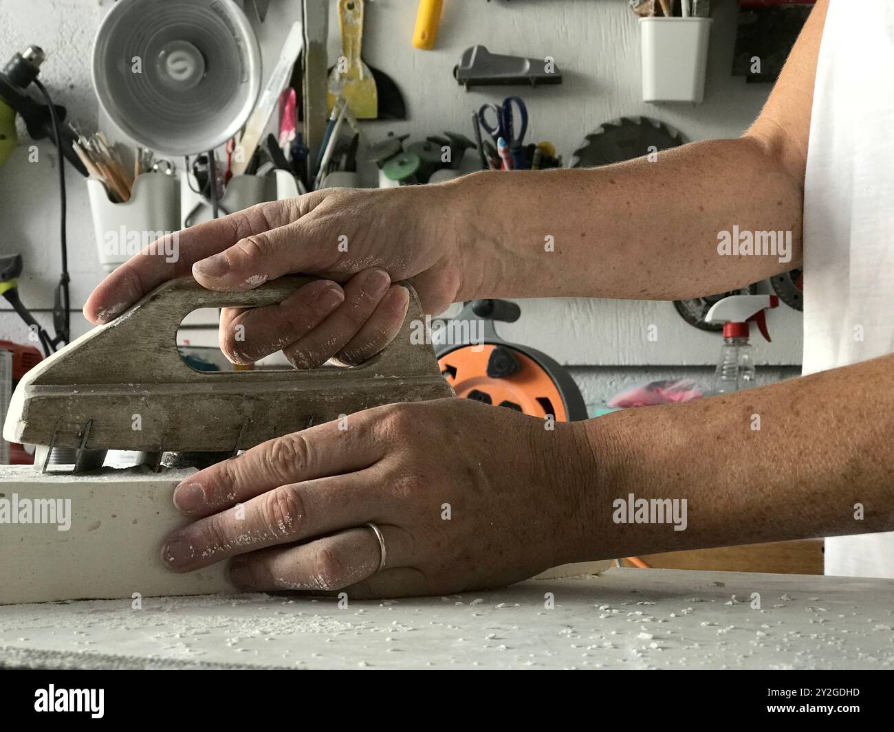 Hand holding a chemin de fer tool for stone carving with tools in the background Stock Photo
