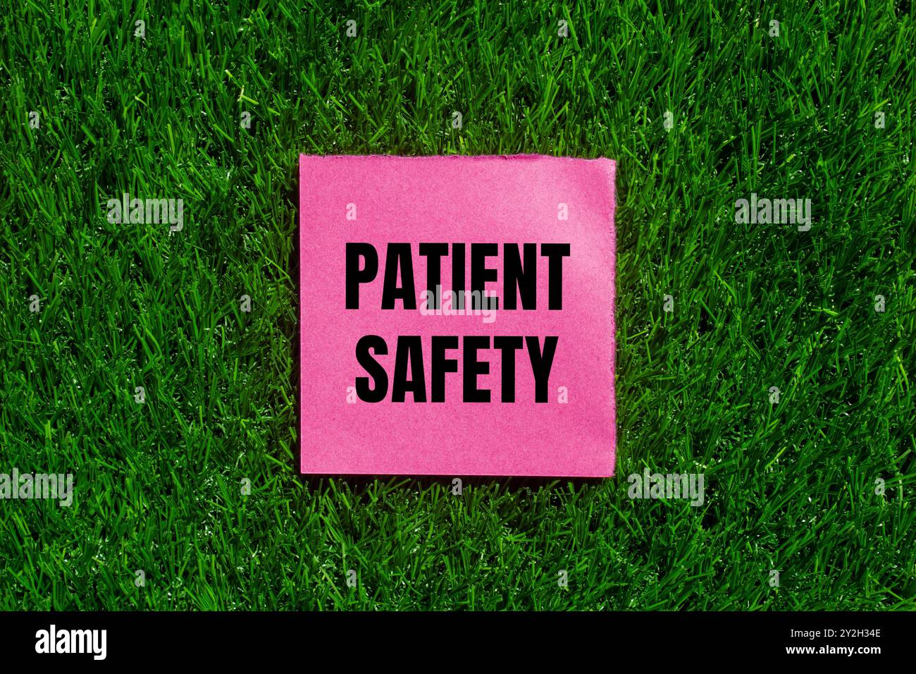 Patient safety message written on ripped torn pink paper with green ...