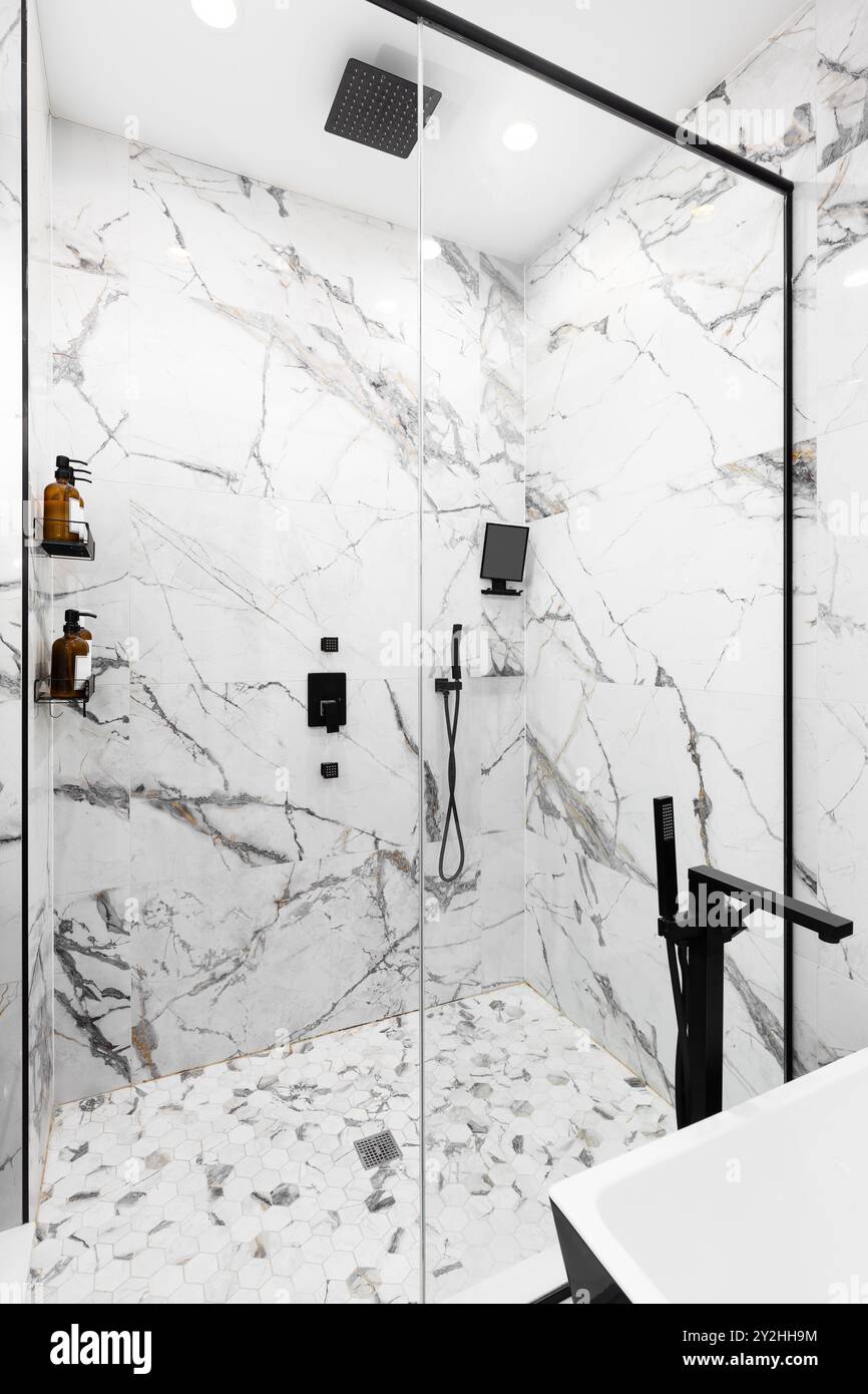 A luxury walk-in shower with marble tile walls, hexagon tile flooring ...