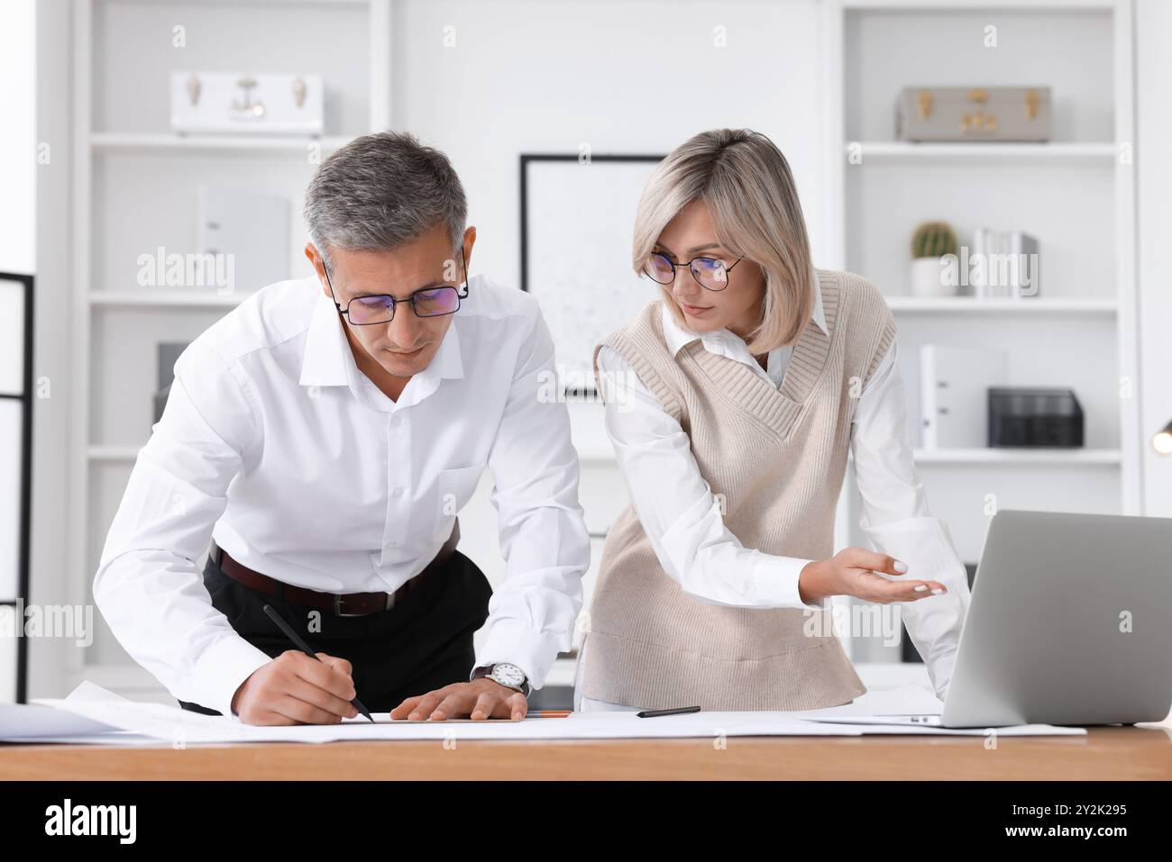 Architects making engineering drawing at wooden table in office Stock Photo