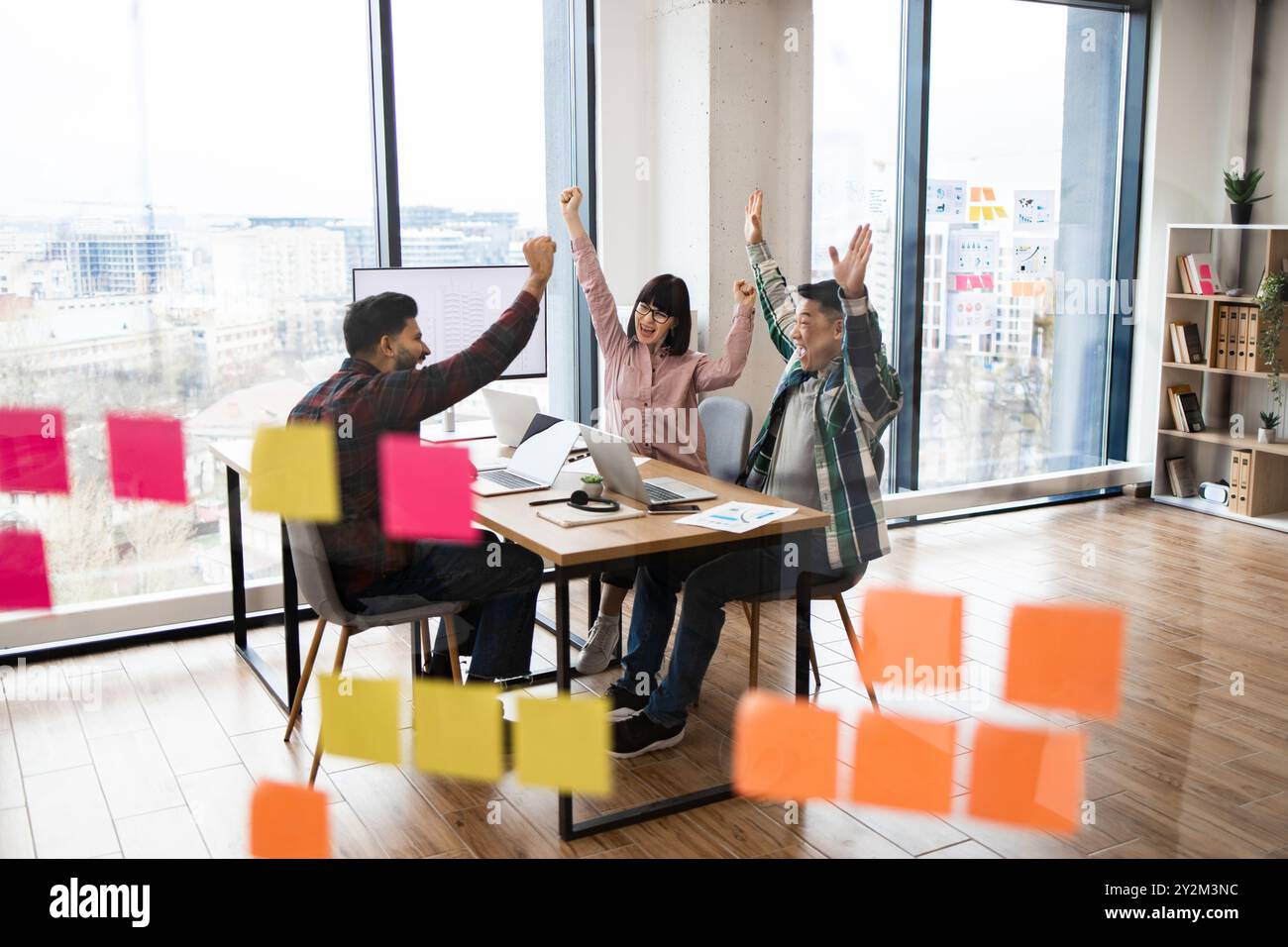 Team celebrating success in modern office setting Stock Photo
