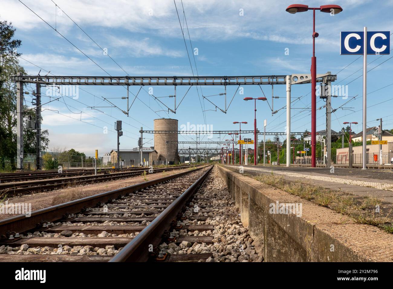 Wasserbillig, Luxembourg - September 7, 2024: Railway tracks stretch away from a train station featuring a circular tower and various signal posts und Stock Photo