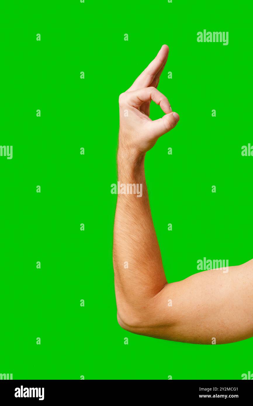 Hand Gesture Signifying Approval Against Bright Green Background Stock
