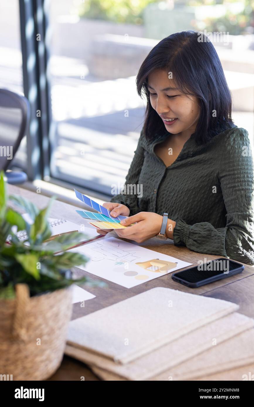 In office, Reviewing color swatches, asian woman planning interior ...