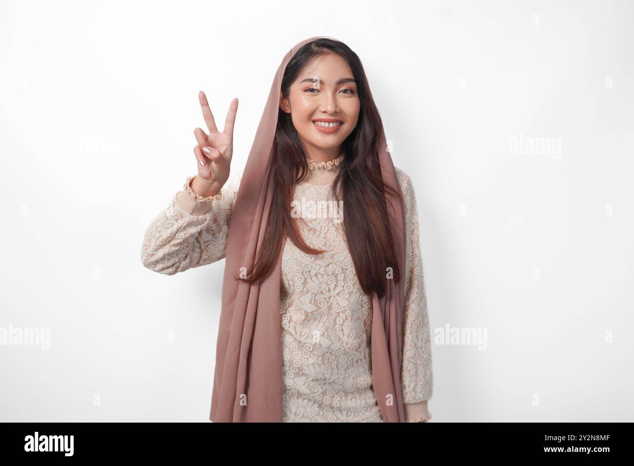 Portrait of attractive Asian Muslim woman wearing veil hijab giving ...