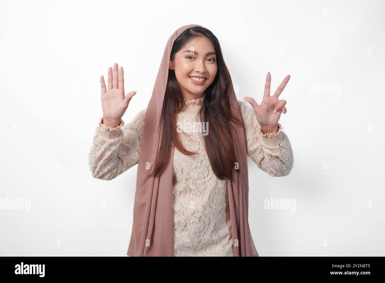 Portrait of attractive Asian Muslim woman wearing veil hijab giving ...