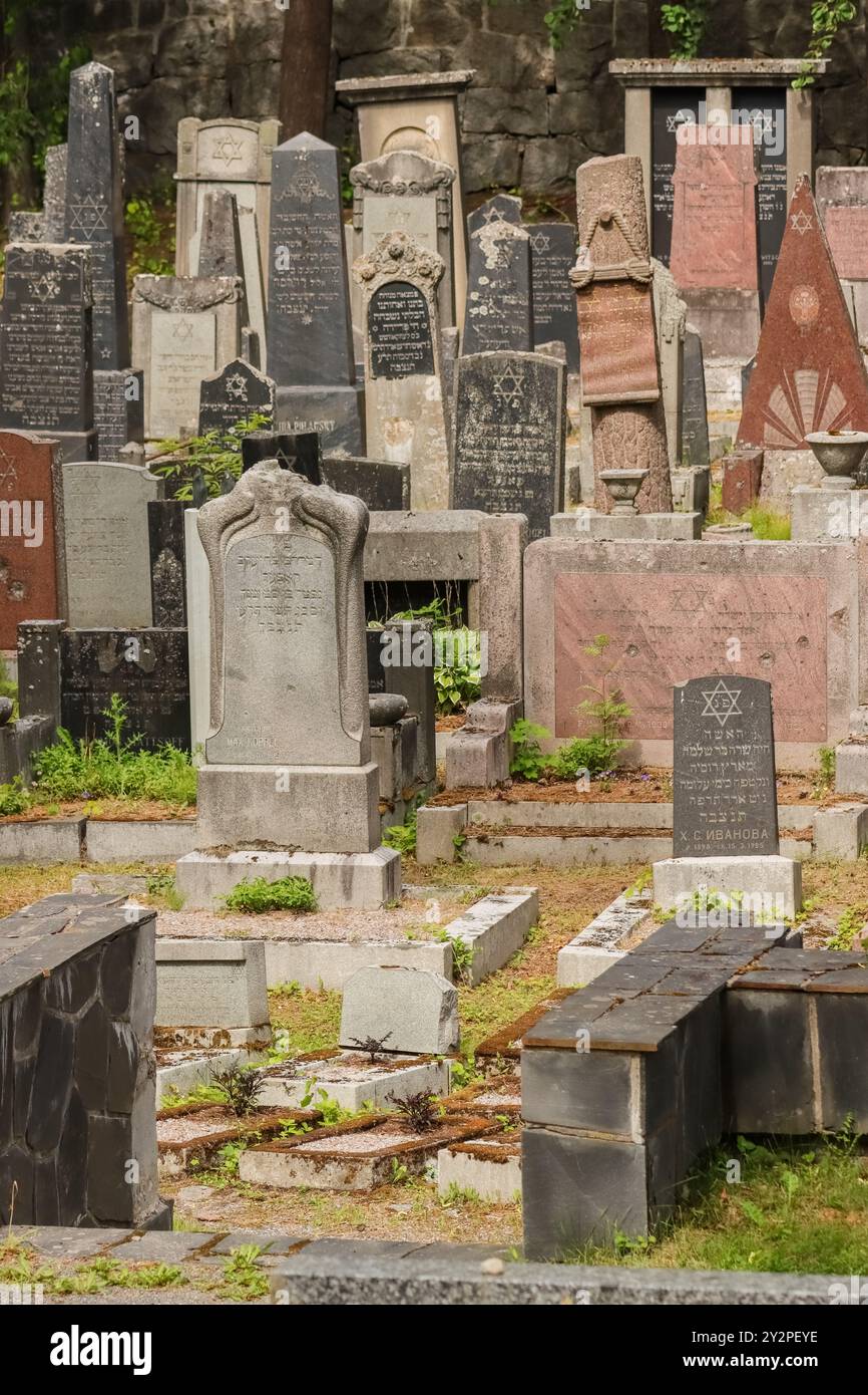 An old Jewish cemetery in Hietaniemi, Helsinki. Several tombstones have Hebrew text and Jewish symbols. A cloudy day in June 2024. Stock Photo