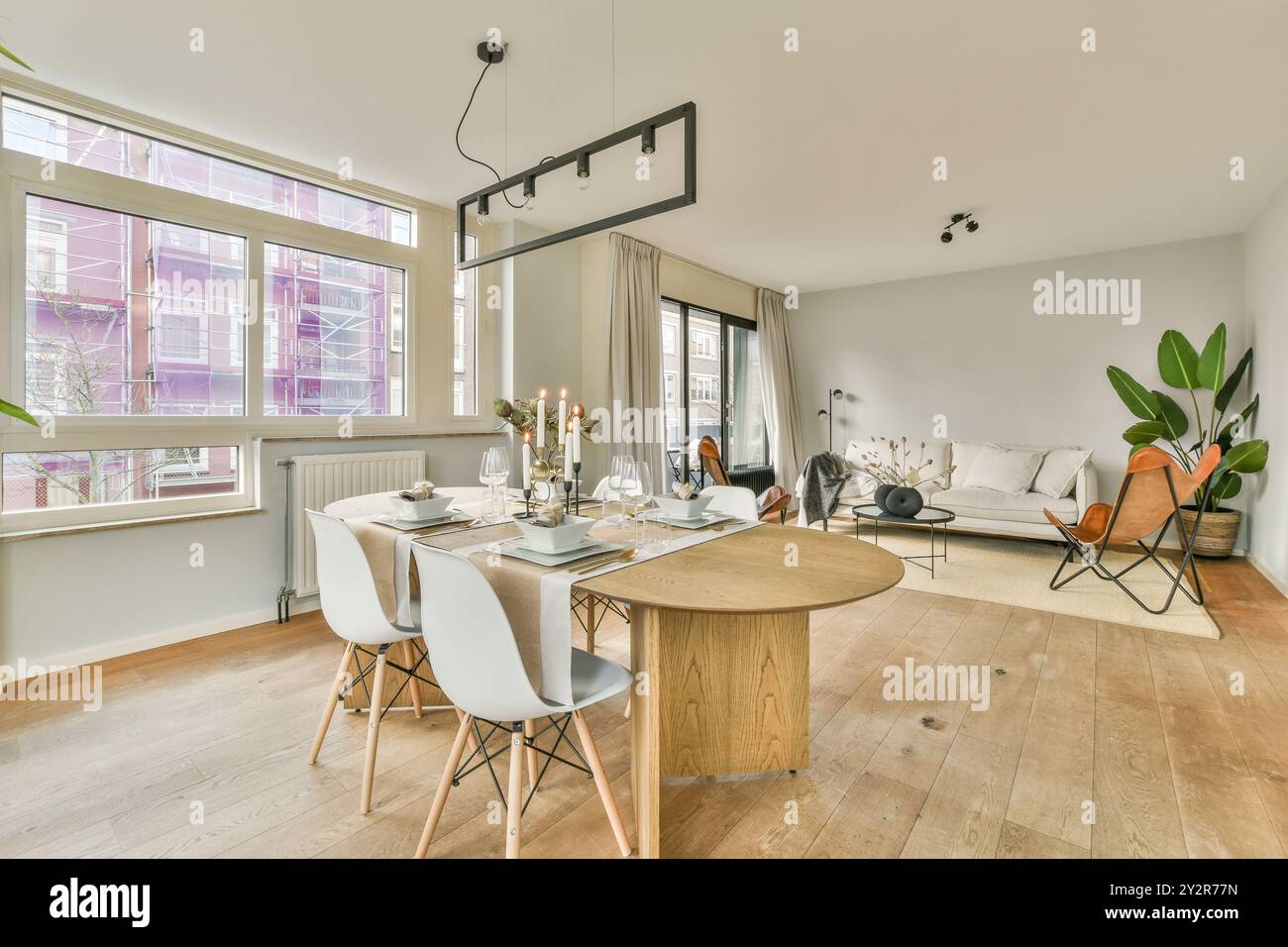 A contemporary living room seamlessly blends with a chic dining space ...