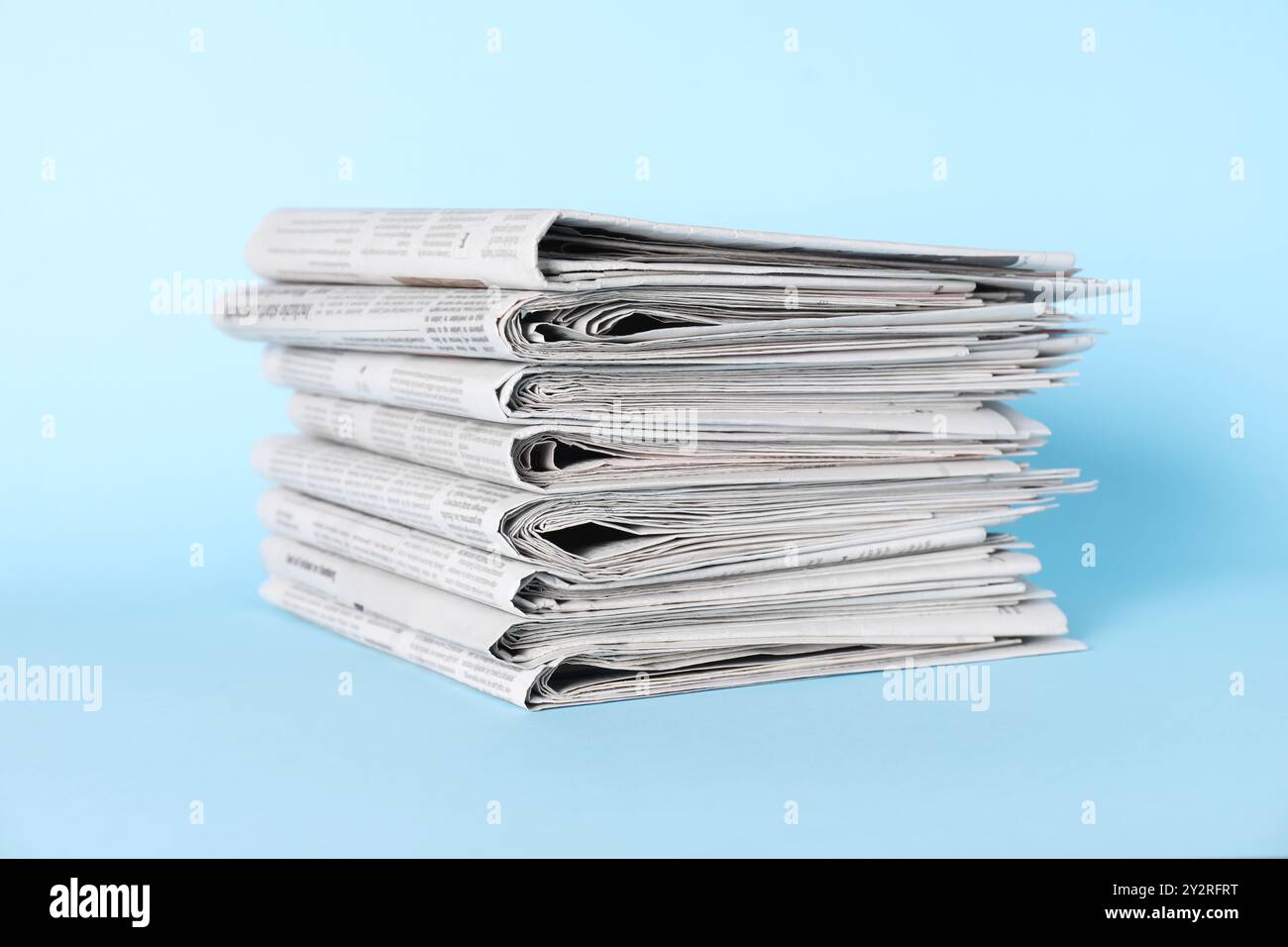 Stack of newspapers on light blue background Stock Photo