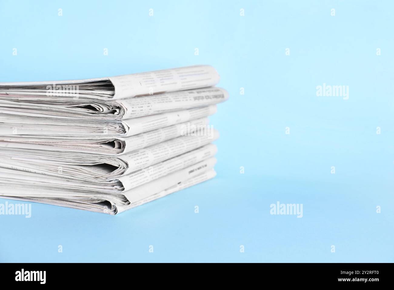 Stack of newspapers on light blue background, space for text Stock Photo