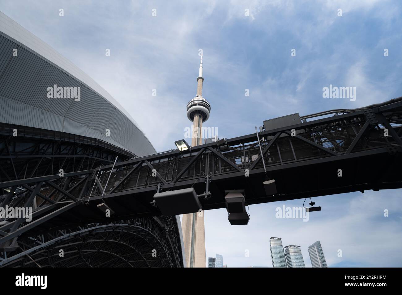 A view of the CN Tower and surrounding buildings from beneath a metal ...