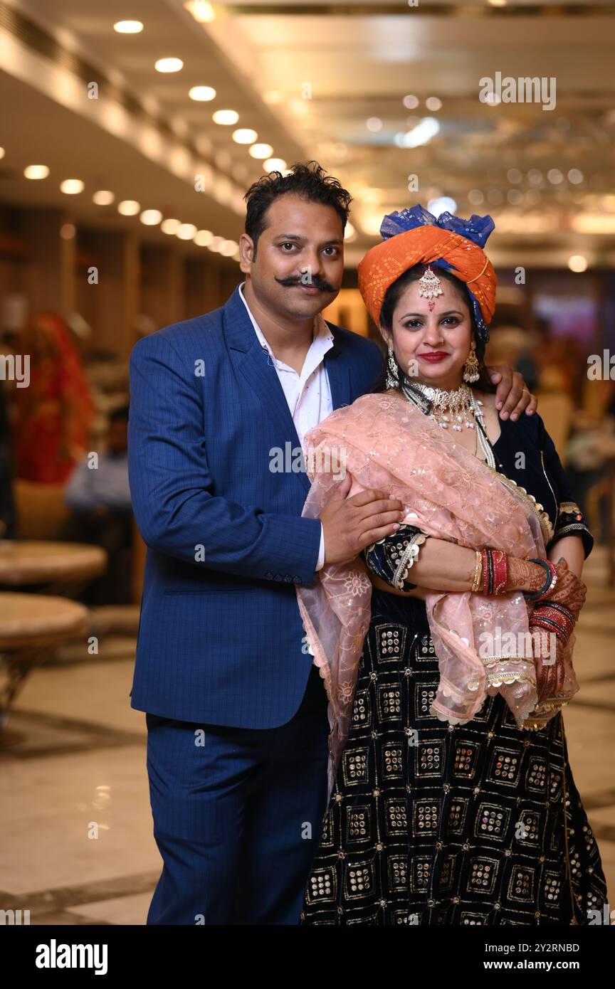 A couple in traditional Indian attire posing for a photograph at a ...